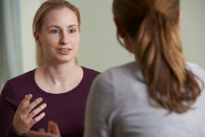 A woman discusses addiction recovery with a counselor