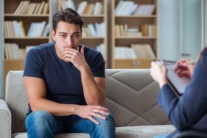 a man talks with a therapist at a meth addiction treatment program